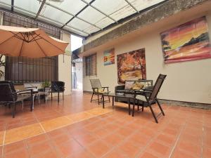 a room with a table and chairs and an umbrella at Acogedora suite privada en Urdesa, Guayaquil in Guayaquil