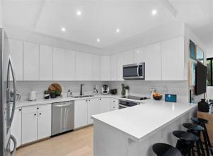 eine Küche mit weißen Schränken und einer weißen Arbeitsplatte in der Unterkunft Key Biscayne Elegance Modern 3 Bedroom Condo in Miami