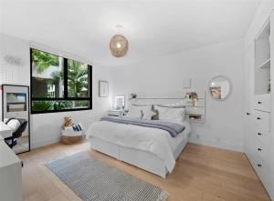 ein weißes Schlafzimmer mit einem großen Bett und einem Fenster in der Unterkunft Key Biscayne Elegance Modern 3 Bedroom Condo in Miami