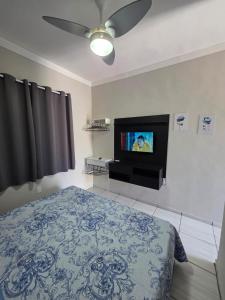 a bedroom with a bed and a flat screen tv at Kitnet na Zona Industrial Sorocaba in Sorocaba