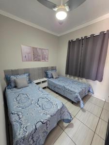 a bedroom with two beds and a window at Kitnet na Zona Industrial Sorocaba in Sorocaba