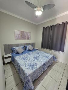 a bedroom with a blue bed with a ceiling fan at Kitnet na Zona Industrial Sorocaba in Sorocaba