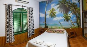 a bedroom with a bed and a mural of the beach at Bungalows Punta Azul in Villa Carlos Paz +128 photos
