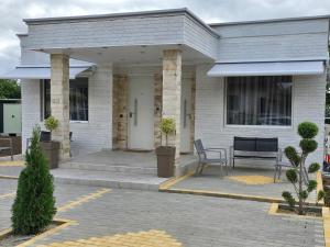 a white brick house with a chair on a patio at White House in Tríkala