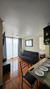 a living room with a table and chairs and a couch at Departamentos Amoblados R&M in Santiago