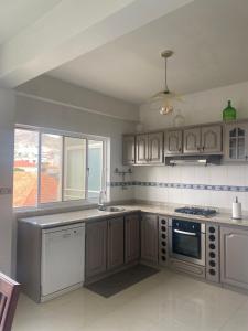 a kitchen with white cabinets and a stove top oven at Mindelo Urban Apartment in Mindelo