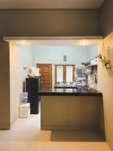 cocina con nevera negra y encimera en Villa Restu 5 Cozy 2BR Mountain View in Puncak, en Paragajen