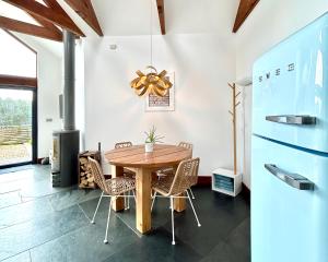 马根波思Merlin Farm Cottages short walk to Mawgan Porth Beach and central location in Cornwall的配有木桌椅的餐厅
