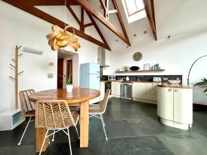 a kitchen with a wooden table and chairs at Merlin Farm Cottages short walk to Mawgan Porth Beach and central location in Cornwall in Mawgan Porth