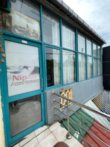 a store front with blue doors and windows at Nipun Apartment in Hikkaduwa +5 photos