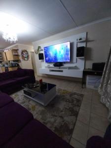 un soggiorno con una grande TV a schermo piatto di Lubsman Apartments a Centurion