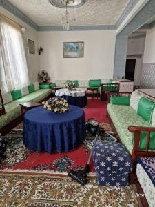 uma sala de estar com dois sofás e uma mesa azul em Benaliem house em Tânger