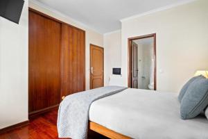 Un dormitorio con una cama grande y un armario de madera. en Ribeira Brava Studios - H, en Ribeira Brava
