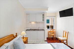 Un dormitorio con una cama y una pequeña cocina. en Ribeira Brava Studios - H, en Ribeira Brava