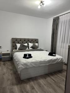 Un dormitorio blanco con una cama grande con zapatos negros. en CASA RAUL, en Poiana Mărului