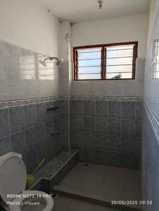 a bathroom with a shower and a toilet and a window at Serviced 4 bedroom apartment in Mombasa
