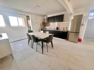 a kitchen and dining room with a table and chairs at Soleil Couchant Apt 8 in Flic-en-Flac