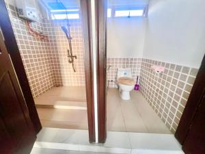 a small bathroom with a toilet and a shower at Soleil Couchant Apt 8 in Flic-en-Flac