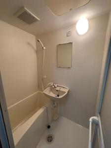 ein Badezimmer mit Waschbecken und Badewanne in der Unterkunft Arusa-Ishite 2F in Matsuyama + 36 Fotos