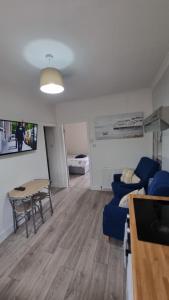 ラーグスにあるCove Bay 1 Bed Flatのテーブルと青いソファのあるリビングルーム