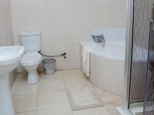 ein Badezimmer mit Toilette, Badewanne und Waschbecken in der Unterkunft Sunrise Serenity Lux Homes in Lilongwe