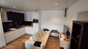 a living room with a couch and a kitchen at Studio Meulebeke Centre in Tielt
