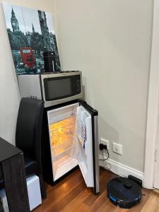 Rose ParkにあるCozy Private 1BR Secure Gate 5mins Burnside Mallの電子レンジが上に置かれたオープン冷蔵庫