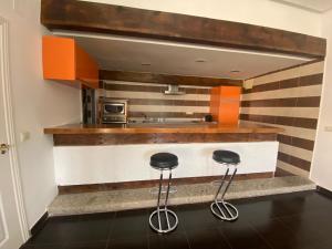 eine Küche mit zwei Hockern vor einer Theke in der Unterkunft La Herradura De San Pedro in Arenas de San Pedro