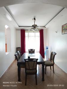 a dining room with a table and chairs and a window at Serviced 4 bedroom apartment in Mombasa