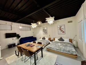 ein Zimmer mit zwei Betten und einem Tisch darin in der Unterkunft Arusa-Ishite 1F in Matsuyama