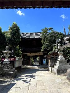 einen Eingang zu einem Gebäude mit einem Tor und einer Treppe in der Unterkunft Arusa-Ishite 1F in Matsuyama