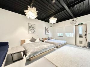 1 Schlafzimmer mit 2 Betten, einem Sofa und Kronleuchtern in der Unterkunft Arusa-Ishite 1F in Matsuyama