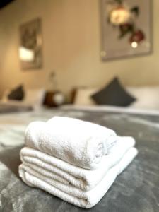 einen Stapel weißer Handtücher auf dem Bett in der Unterkunft Arusa-Ishite 1F in Matsuyama