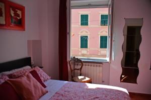 a bedroom with a bed and a window with a building at The window to the sea - a stone's throw from the beach in Genova
