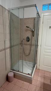 a shower with a glass door in a bathroom at The window to the sea - a stone's throw from the beach in Genova +35 photos