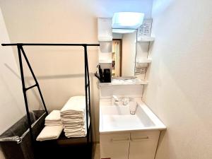 ein kleines Badezimmer mit Waschbecken und Spiegel in der Unterkunft Arusa-Ishite 1F in Matsuyama + 56 Fotos