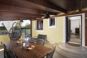 a patio with a wooden table and chairs on a deck at Captain Villa 2 km to the beach in Vintijan