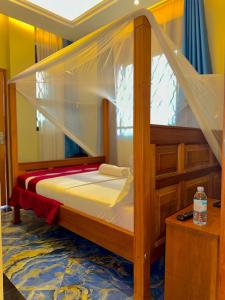 a bedroom with a bunk bed with a canopy at Palm Gardens Guesthouse in Kampala