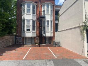 Un estacionamiento vacío frente a un edificio en Captain's Quarters on Lafayette, en Savannah