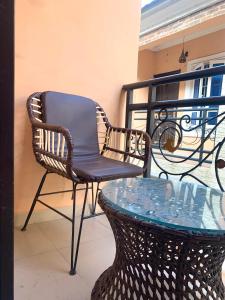 a wicker chair and a glass table on a balcony at Reagal Apartments, WMachine, WiFi, 13 mins DRV from Ikeja, OPIC ESTATE in Agege