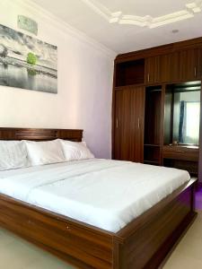 a bedroom with a large bed with white sheets at Reagal Apartments, WMachine, WiFi, 13 mins DRV from Ikeja, OPIC ESTATE in Agege +6 photos