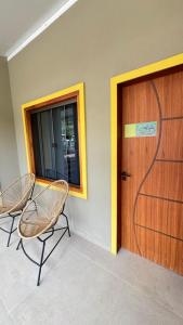 a room with two chairs and a wooden door at Pousada Rancho na Serra in Espera Feliz