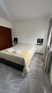 a bedroom with a large bed and two windows at Dormis Bajos Medanales in Victorica +2 photos