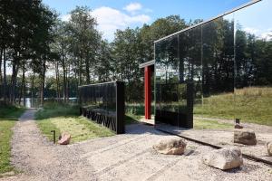 ein Glashaus mit einer roten Tür auf einem Feld in der Unterkunft Juoda Truoba 
