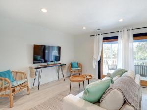a living room with a couch and a tv at Deja Blue B in Tybee Island