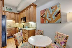 una cocina con armarios de madera, mesa y sillas en Hideaway on Jones, en Savannah