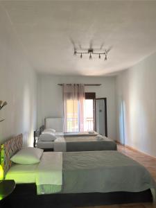 a bedroom with three beds and a window at Ericius House in Ierissos