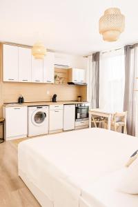 a white kitchen with a washer and dryer at Panorama Sunset Studio in Stara Zagora