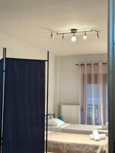 two beds in a bedroom with blue curtains at Ericius House in Ierissos