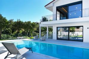 a villa with a swimming pool and a house at Mandarini Luxury Villa Pefkochori 5 bedrooms 12 guests in Pefkohori